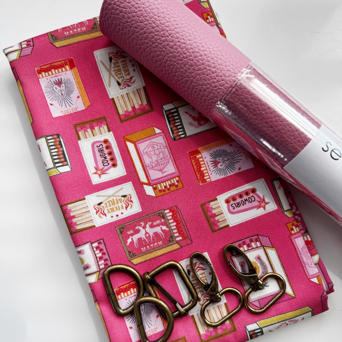 Dusty rose faux leather paired with coordinating pink matchbox print cotton fabric and antique brass bag hardware, perfect for handbags, totes, wallets, crossbody bags, and sewing projects.
