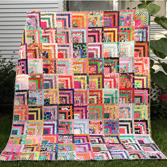Colorful quilt with geometric pattern on grass