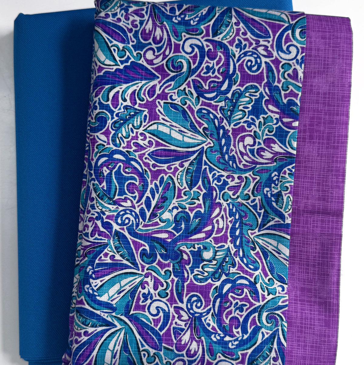 Blue and purple patterned fabric with a plain blue fabric background