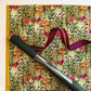 Floral-patterned notebook with a pen and ribbon on a matching background