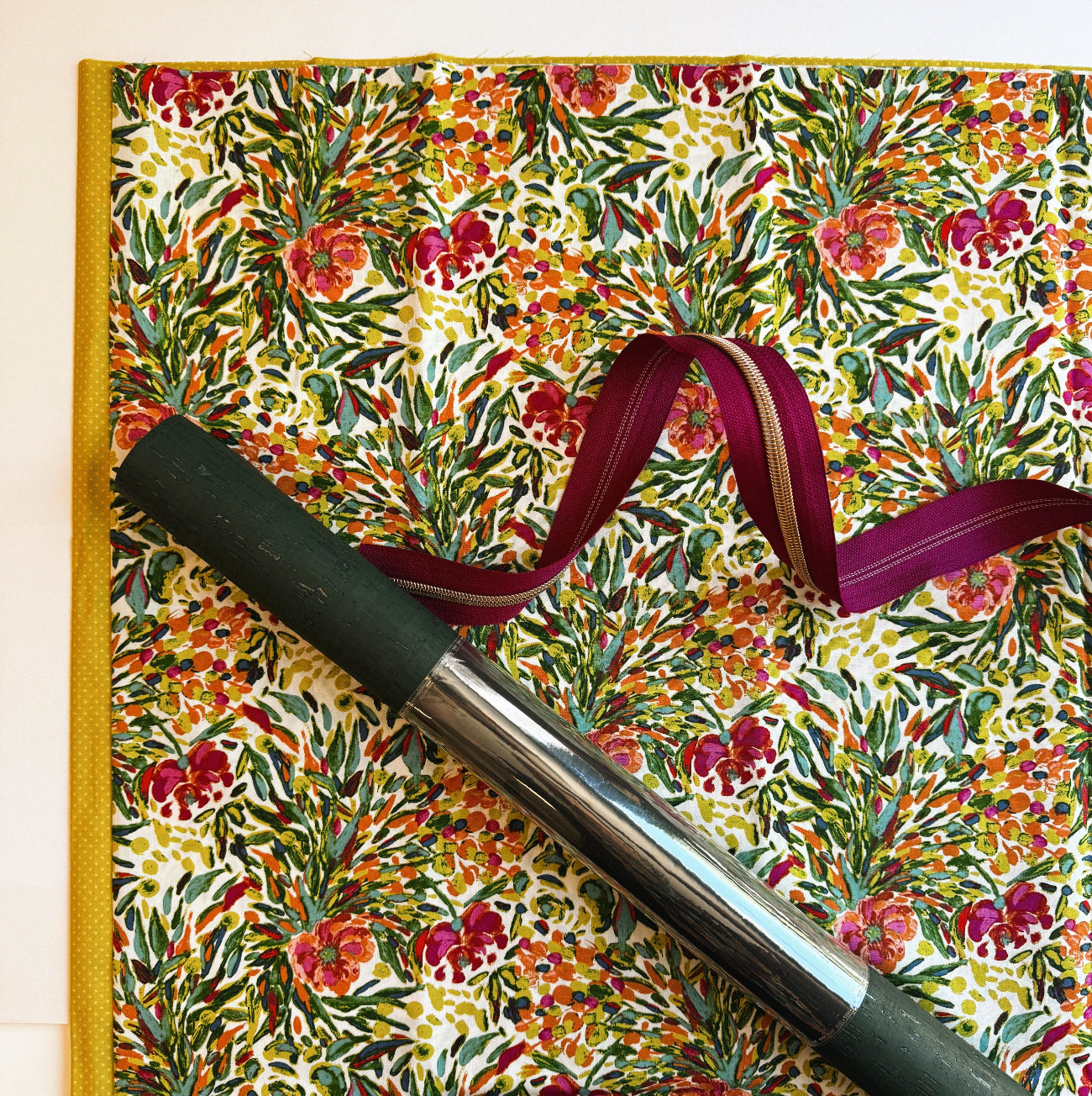 Floral-patterned notebook with a pen and ribbon on a matching background