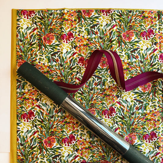 Floral-patterned notebook with a pen and ribbon on a matching background