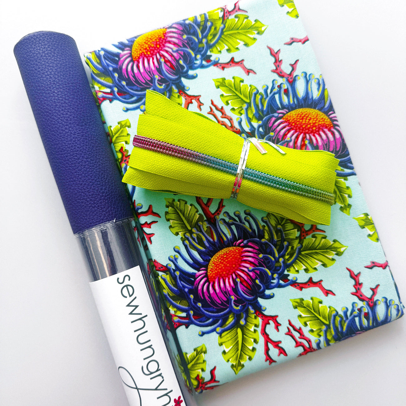 Colorful floral fabric with purple textured faux leather and lime green zipper from Sew Hungry Hippie