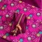 Pink zipper with gold pull on a pink floral fabric background