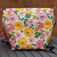 Cream canvas messenger bag with vibrant pink and yellow floral print and green leaves