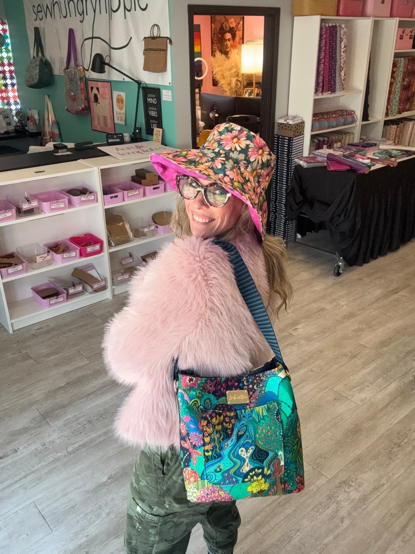 Person wearing a colorful coat with a fur-lined hood in a store setting.