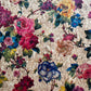 Floral patterned fabric with colorful flowers on a textured beige background