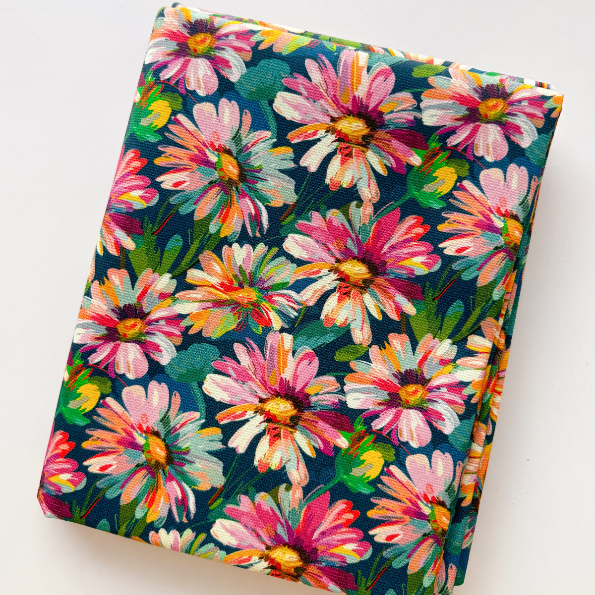 Floral-patterned fabric with pink and yellow flowers on a dark blue background