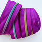 Purple zippers with colorful teeth on a white background