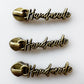 Three identical antique bronze metal zipper pull charms spelling out 'Handmade' vertically on a clean white background.