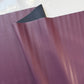 Close-up of purple leather fabric with a white background