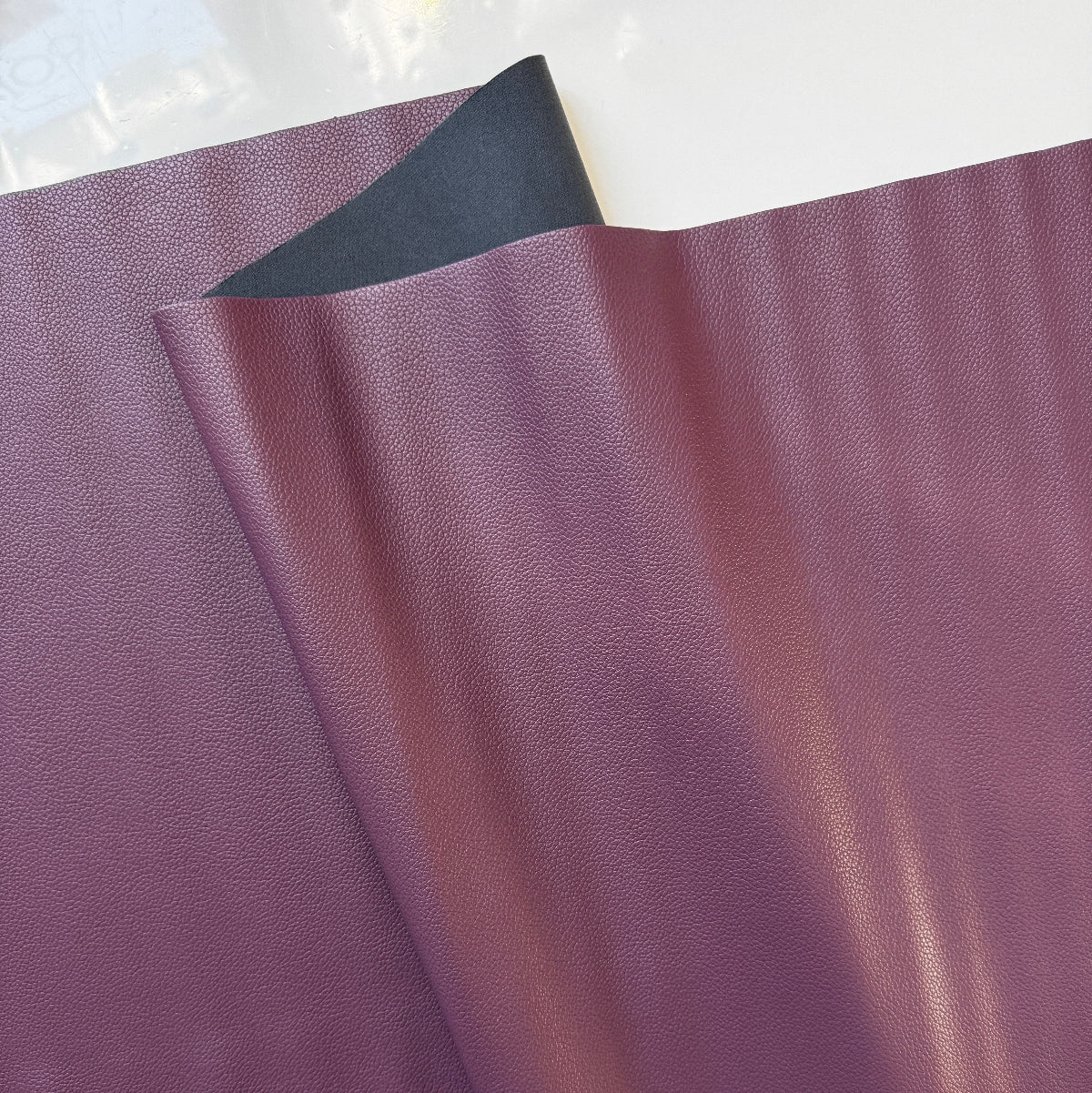 Close-up of purple leather fabric with a white background