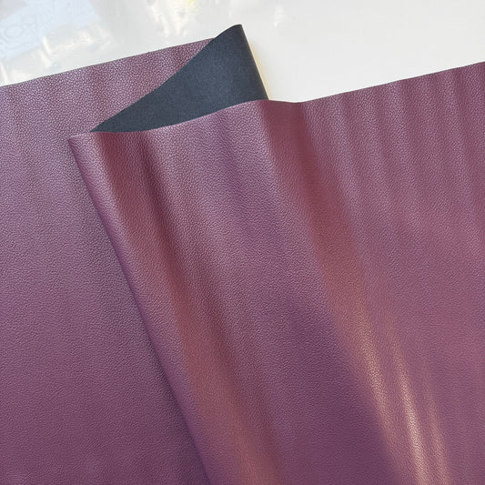 Close-up of purple leather fabric with a white background