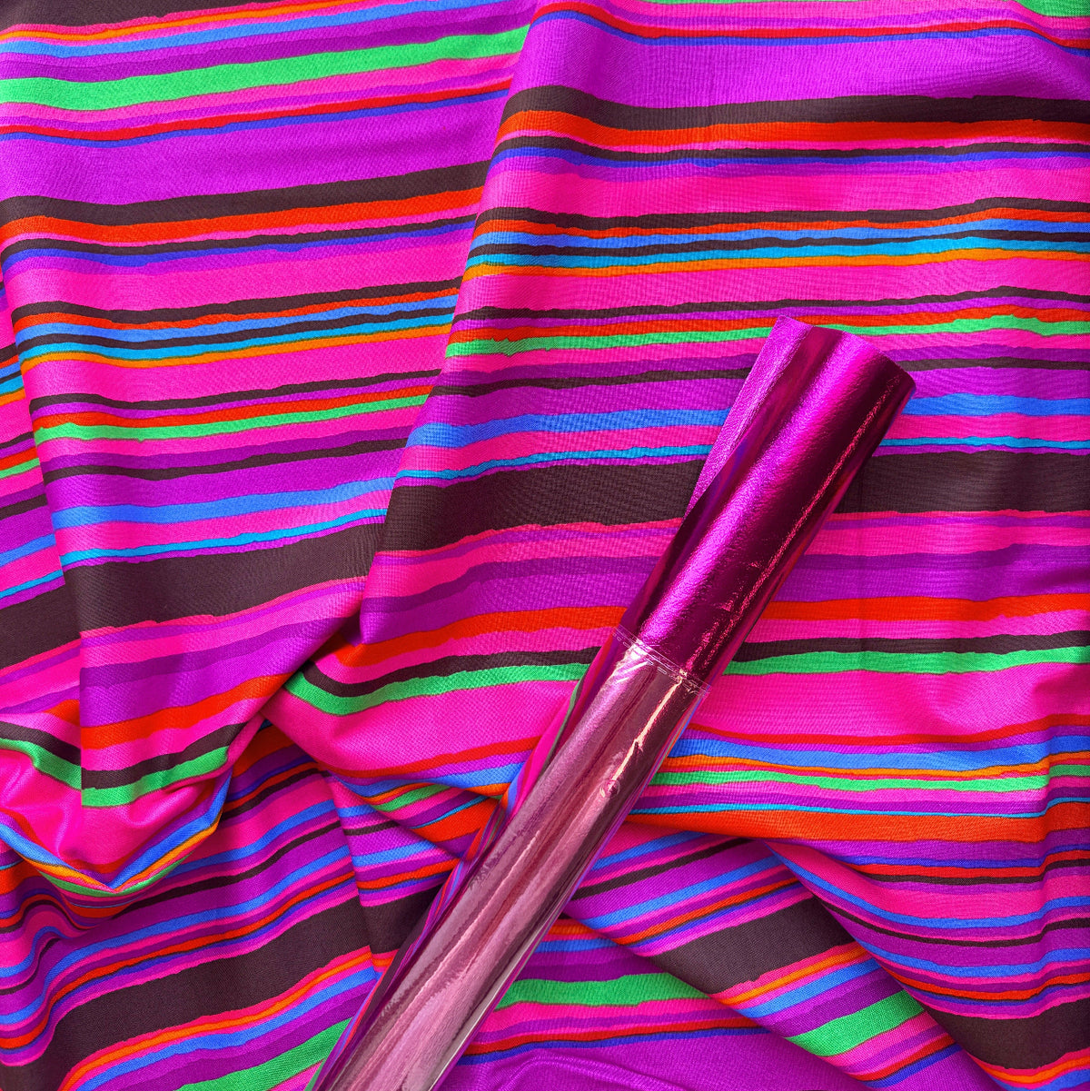 Pink soft vinyl paired with vibrant multicolor striped fabric for bag makin