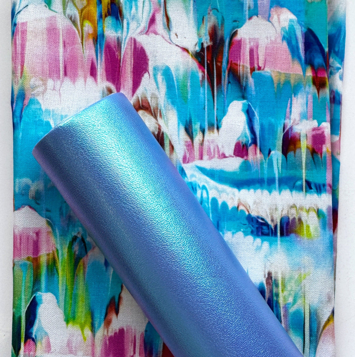 Iridescent blue-purple faux leather paired with colorful paint drip fabric in turquoise, pink, yellow, and purple
