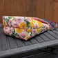 Handmade messenger iris bag in a vibrant pink and yellow floral canvas print paired with an adjustable pink strap.