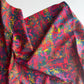 Draped abstract fabric featuring a vibrant, multi-colored graffiti-style pattern in shades of red, blue, yellow, and green.