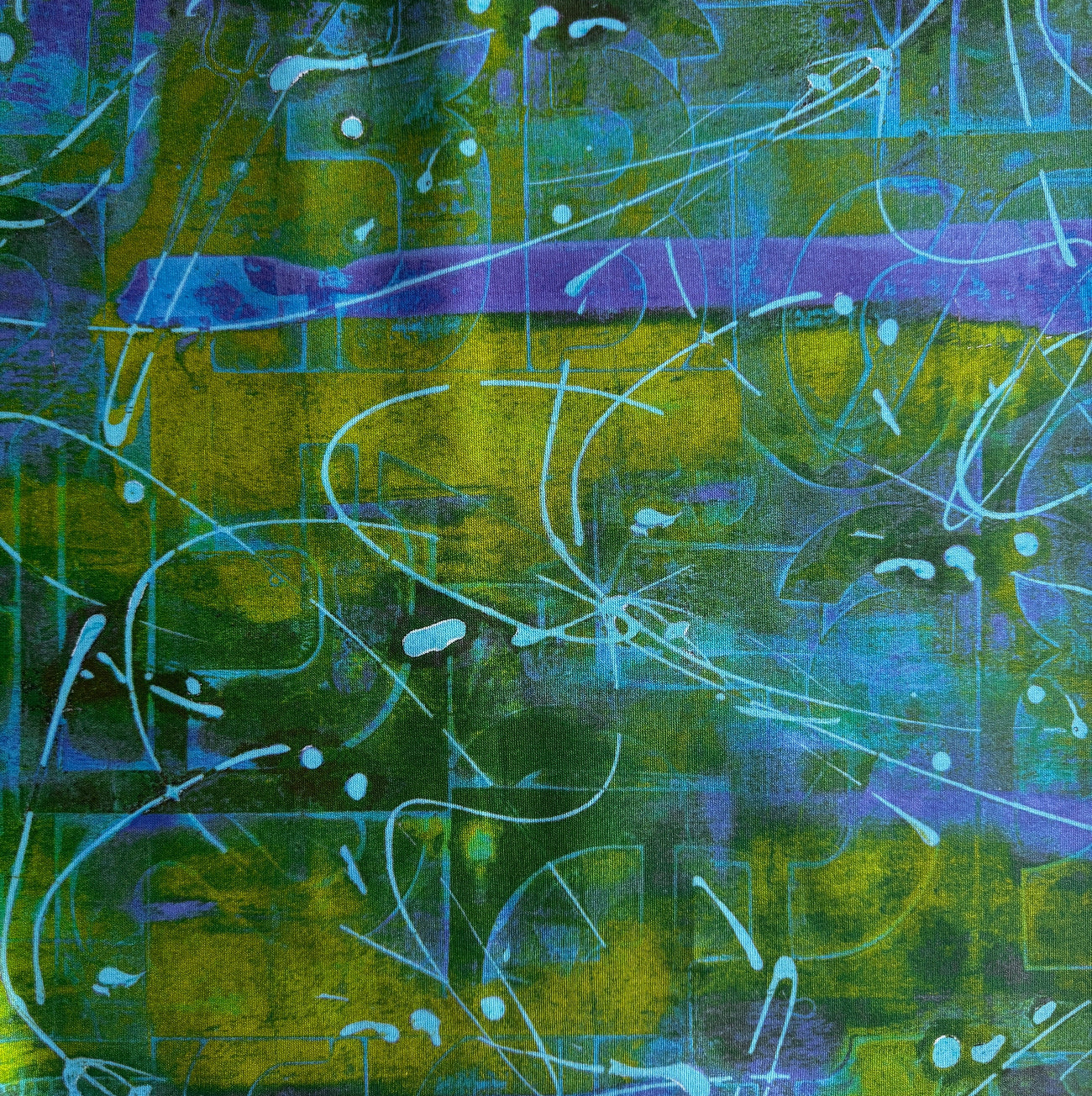 Close-up flat lay of an abstract print fabric featuring a layered green, yellow, and purple pattern with light blue graphic lines.