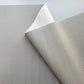 A close-up of a light gray pebbled material sheet with one corner folded back to show the lighter underside, photographed on a plain light background.