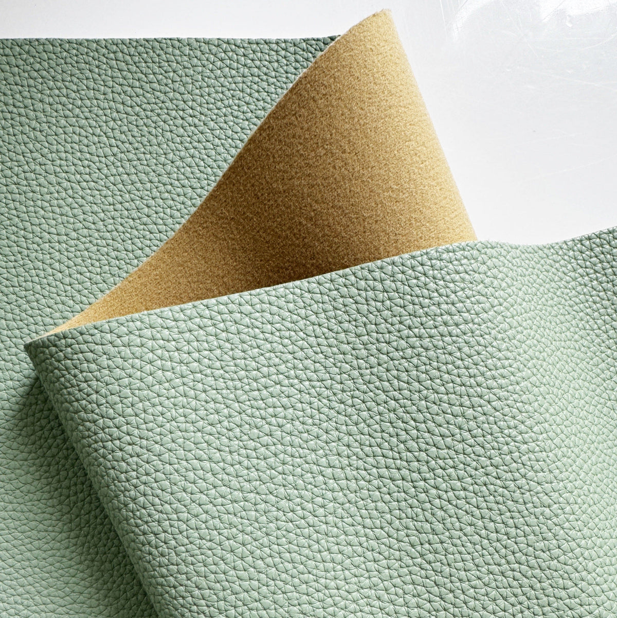 Moonglow New Sage pebbled vinyl faux leather fabric with soft brown-beige brushed backing