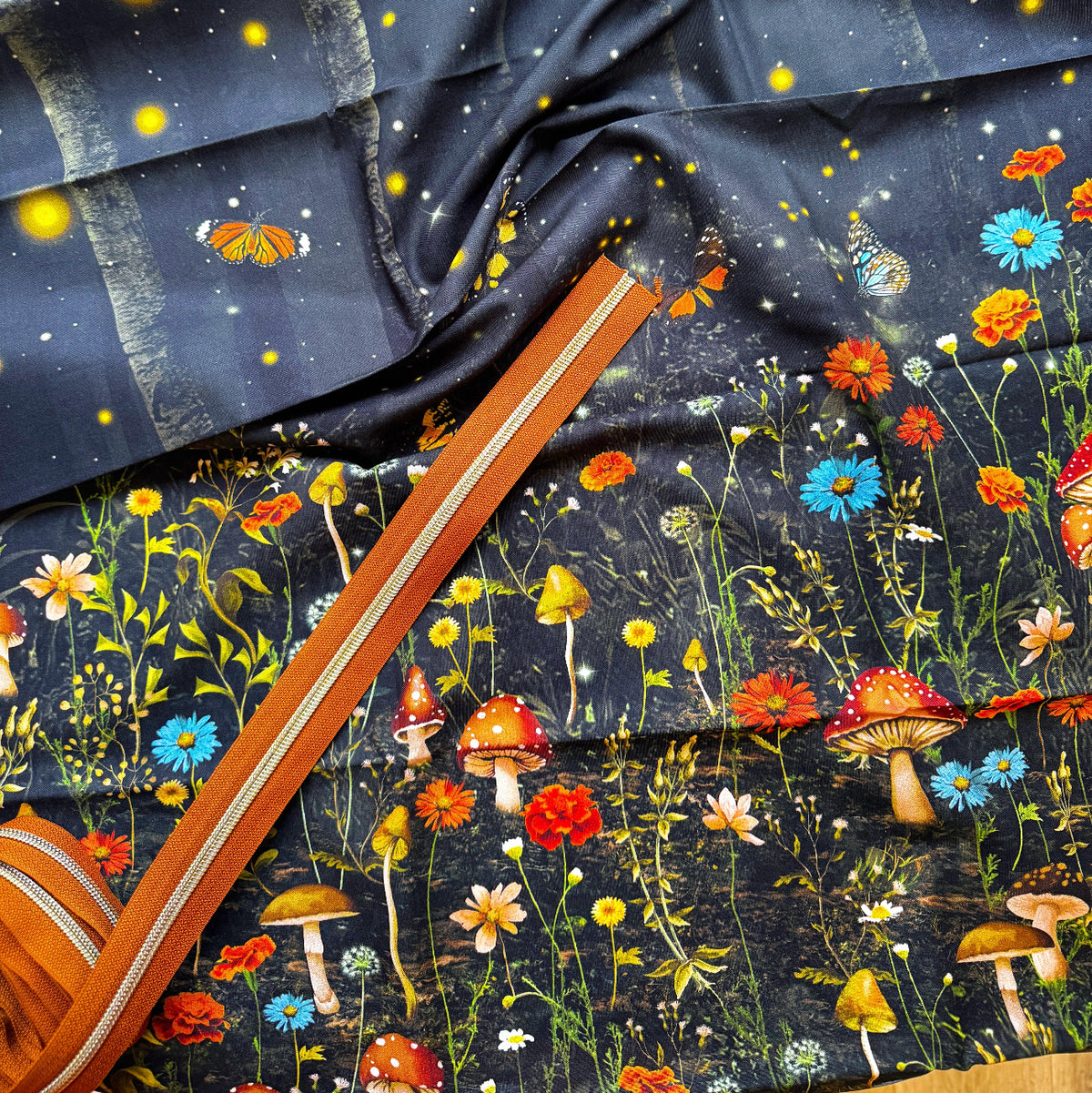 A woodland-themed cotton fabric featuring a dark floral and mushroom print and Toffee Zipper Tape
