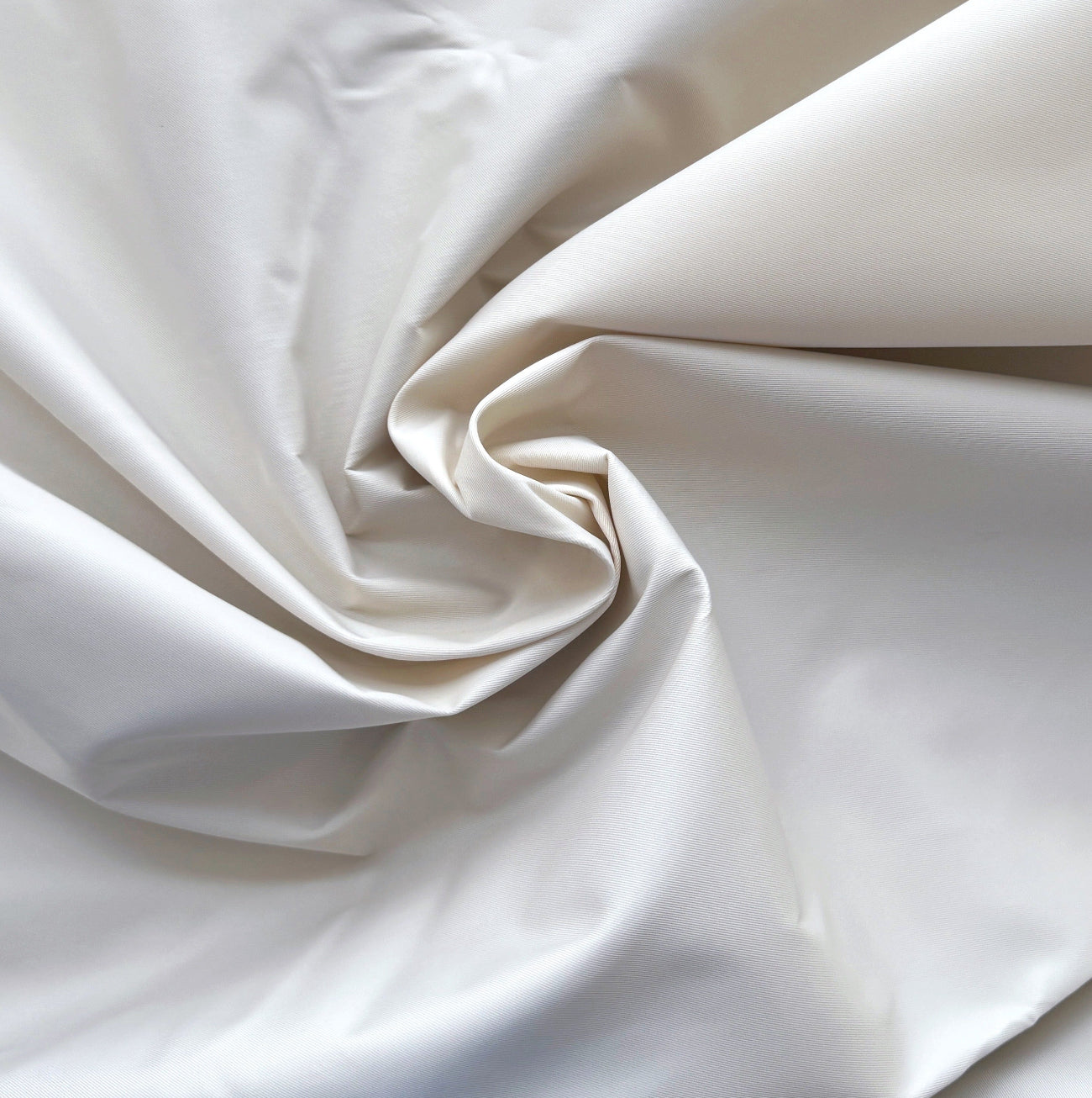 Close-up of beige fabric with folds on a light background