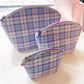 Set of blue plaid shell-shaped zipper pouches featuring a soft tartan pattern in three different sizes.