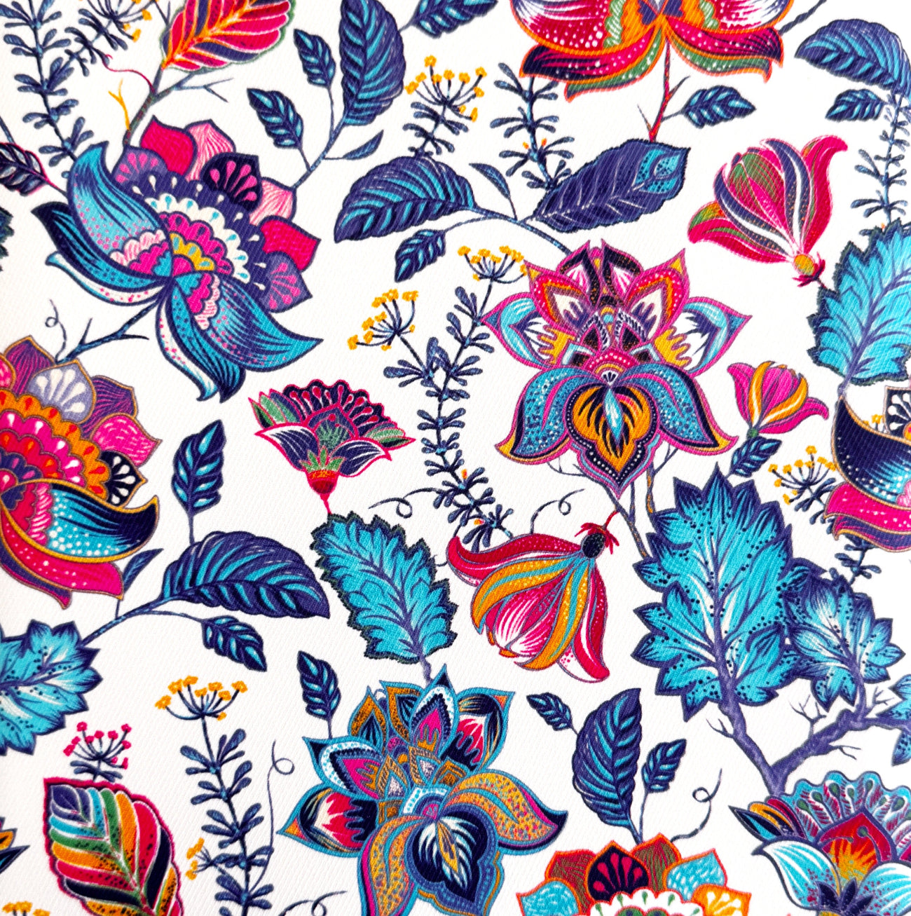 White fabric featuring a vibrant, stylized floral pattern in bold turquoise, magenta, and purple, perfect for craft projects.