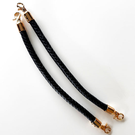 Two black braided rope pet collars with gold-tone metal clasps, displayed on a clean white background.