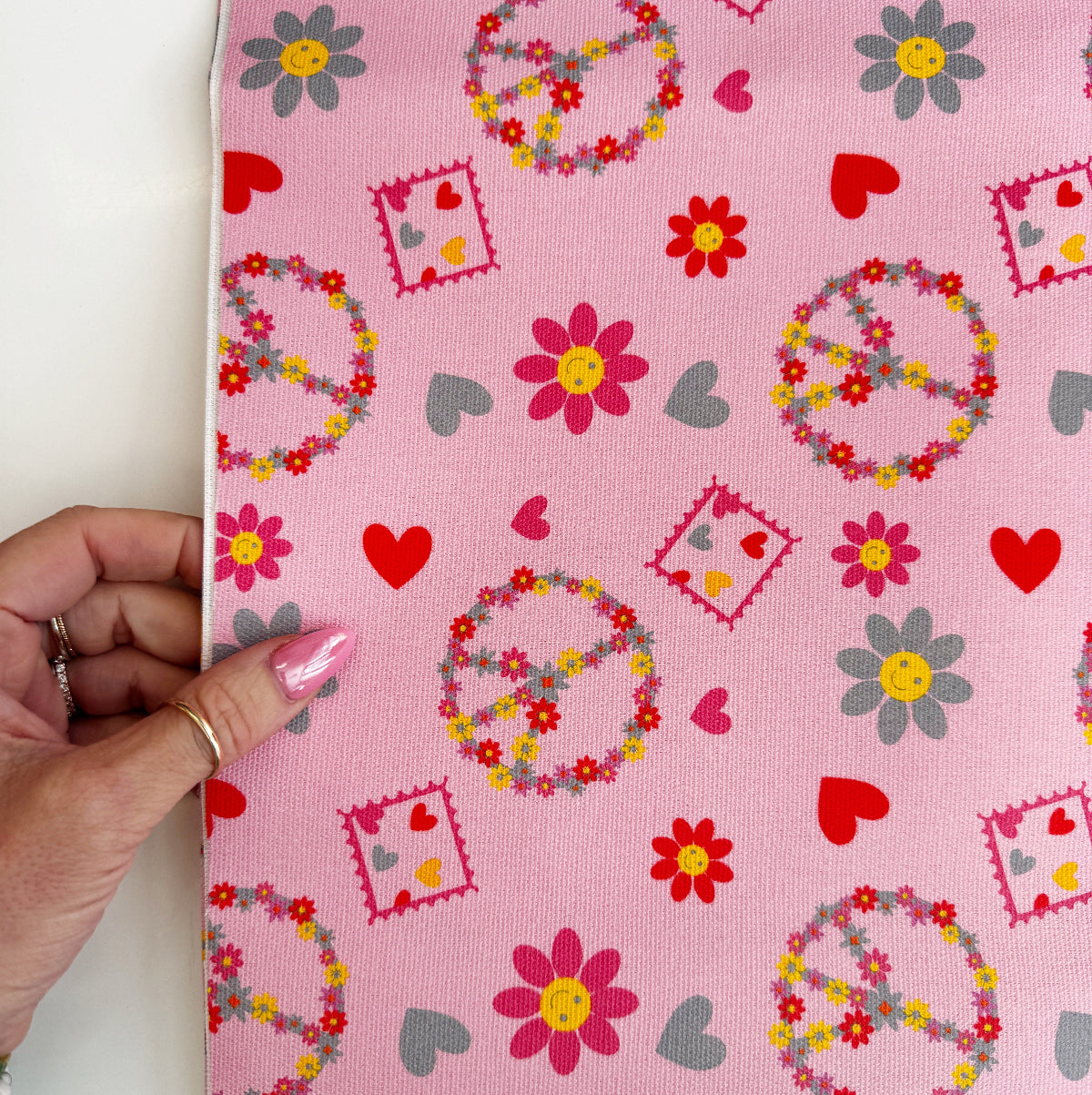 hand holding canvas fabric with peace and flowers