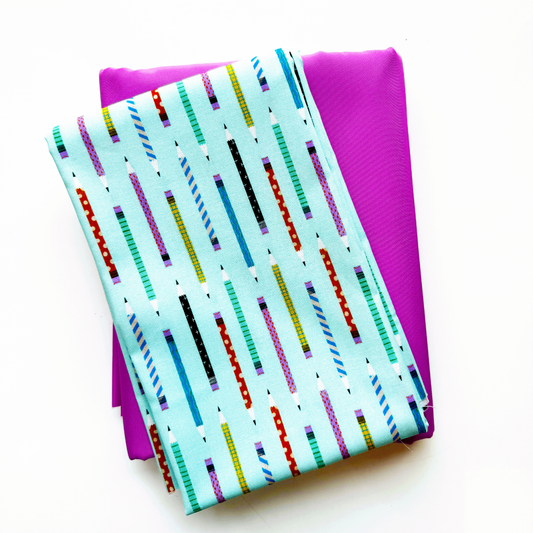 Folded Aqua Blue Pencil Thief print fabric from the Hall Pass collection by Faye Guanipa for Dear Stella Fabrics, on top of folded pink bonded nylon for bag making