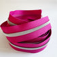 Pink zippers with silver teeth on a white background