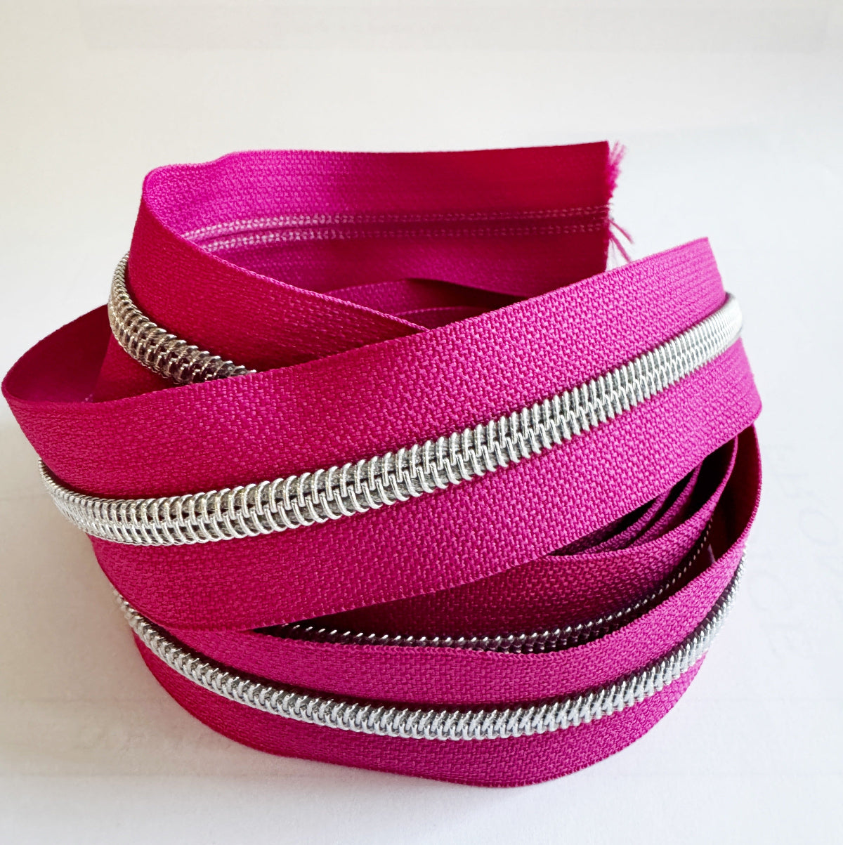 Pink zippers with silver teeth on a white background