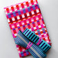Pink gingham fabric with turquoise striped webbing and silver zipper for sewing and bag making.