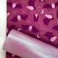 Pink iridescent vinyl paired with purple bat print cotton fabric for sewing Halloween bags, wallets, and handmade accessories.