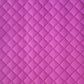 A close-up of a quilted fabric texture in a vibrant magenta pink, showing a repeating diamond pattern stitched together.