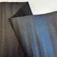 Textured fabric with a herringbone pattern in black and blue on a white background