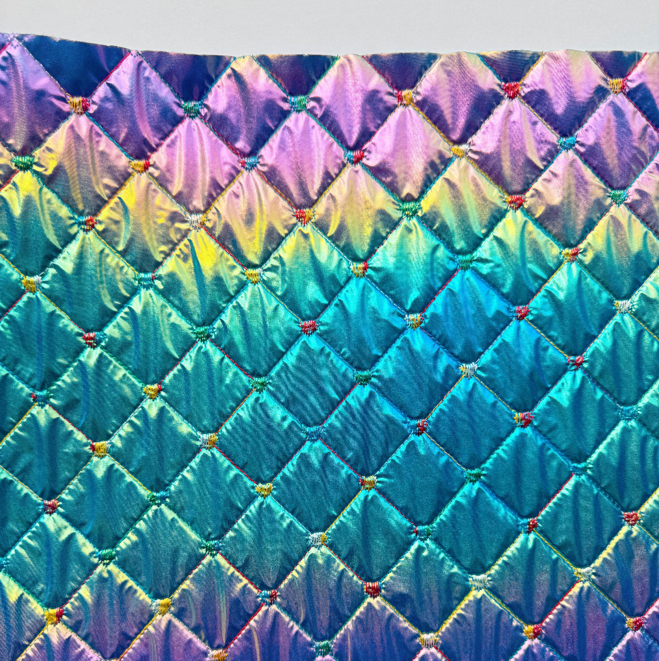 Multicolored quilt with diamond pattern on a white background