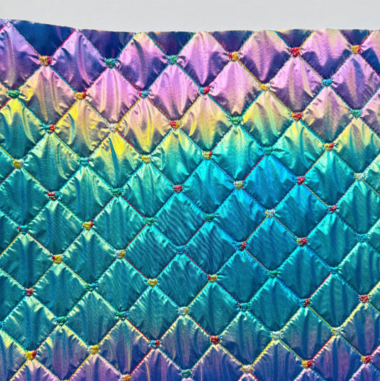 Multicolored quilt with diamond pattern on a white background