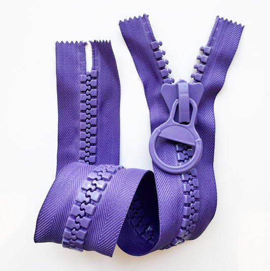Chunky purple molded plastic zipper with a round ring pull and textured herringbone fabric tape