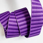 A 1.5-inch wide jacquard woven webbing strap featuring a monochromatic dark purple and medium purple horizontal stripe pattern, neatly coiled against a white background.