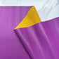 A close-up shot of a textured, pebbled faux leather vinyl fabric sheet. The main side is a vibrant orchid purple, and a corner is folded over to reveal a contrasting mustard-yellow backing material. The fabric is set against a white marble-patterned background.