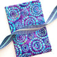 Folded purple and teal batik fabric with a circular mosaic pattern, paired with a coordinating blue and purple striped zipper tape with silver teeth.