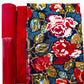 Red pebbled vinyl, textured red geometric fabric, and navy cotton with Flowered Engrams floral print from the Trinkets Fusion collection for bag making