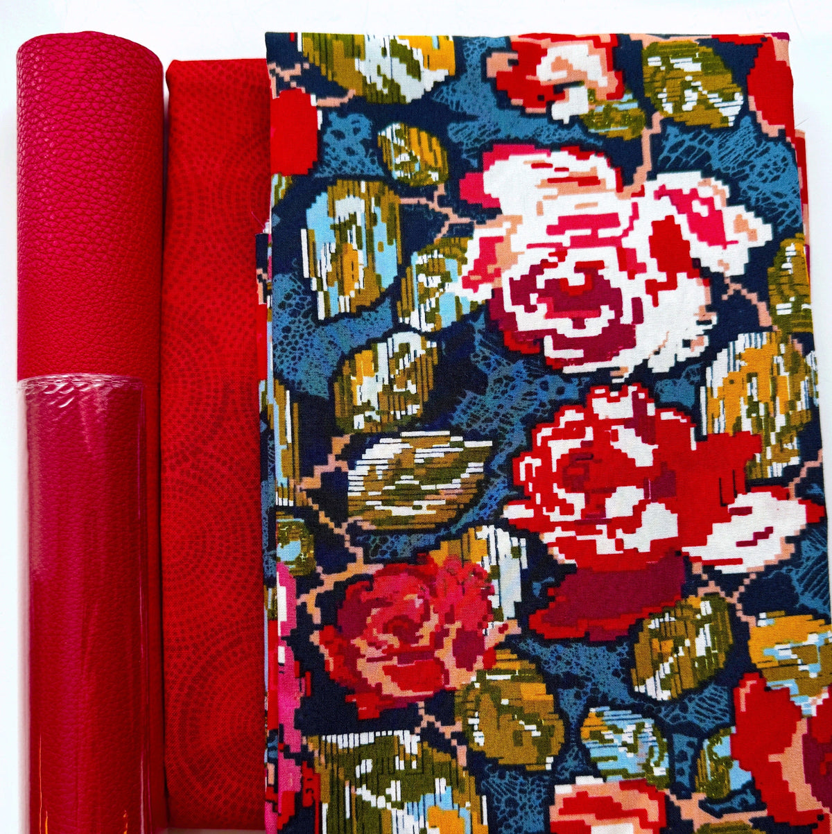 Red pebbled vinyl, textured red geometric fabric, and navy cotton with Flowered Engrams floral print from the Trinkets Fusion collection for bag making