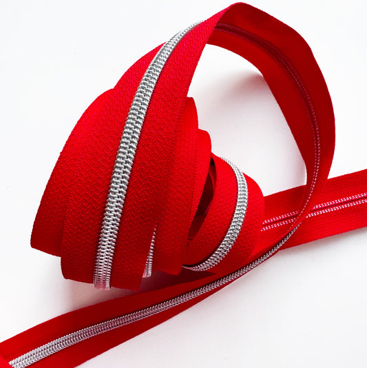 Red zipper tape by the yard on a white background