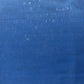 A close-up of a textured blue cork surface with subtle horizontal brushstrokes and slight tonal variation.