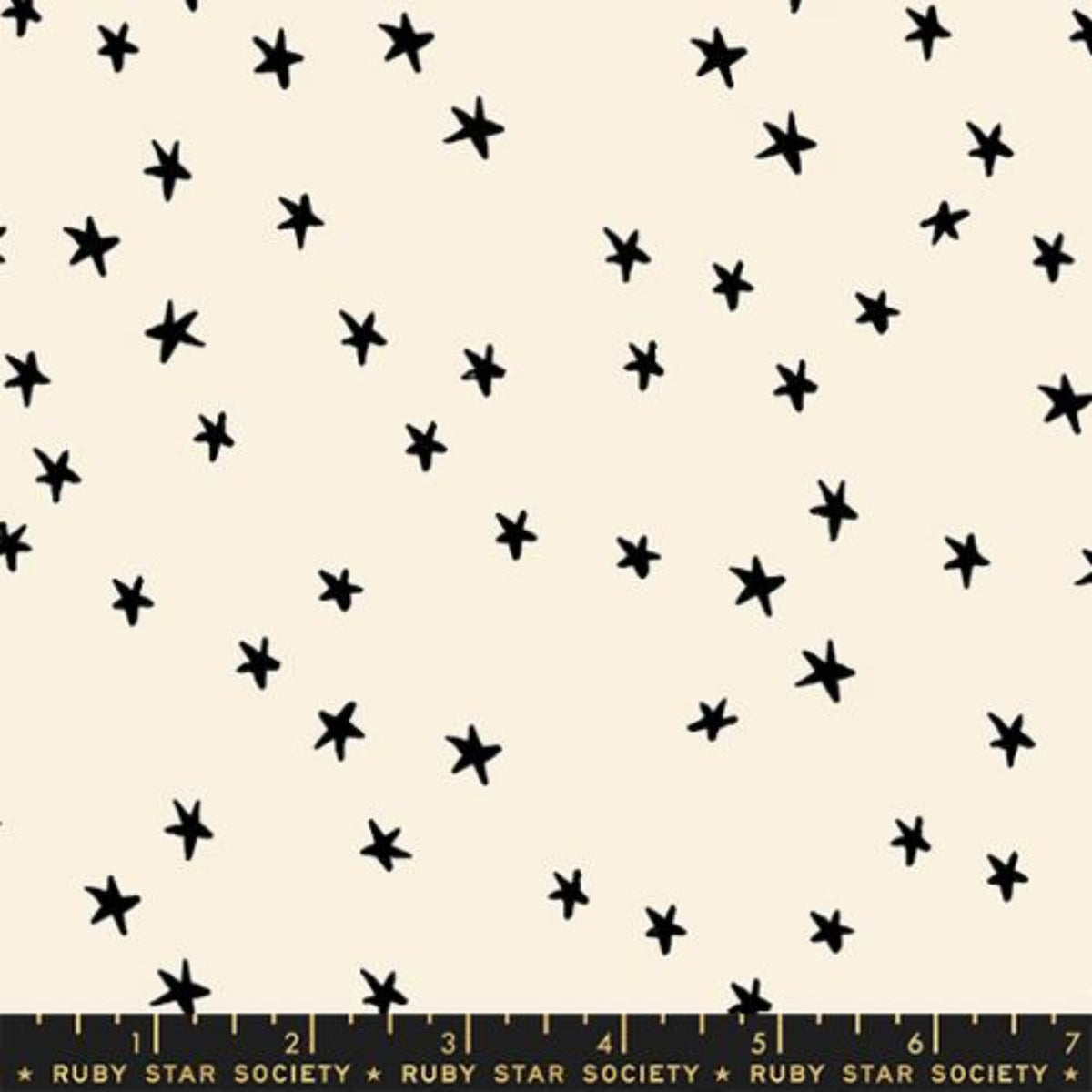 Cream-colored fabric with a scattered pattern of small, hand-drawn black stars, featuring a Ruby Star Society measuring ruler at the bottom edge.