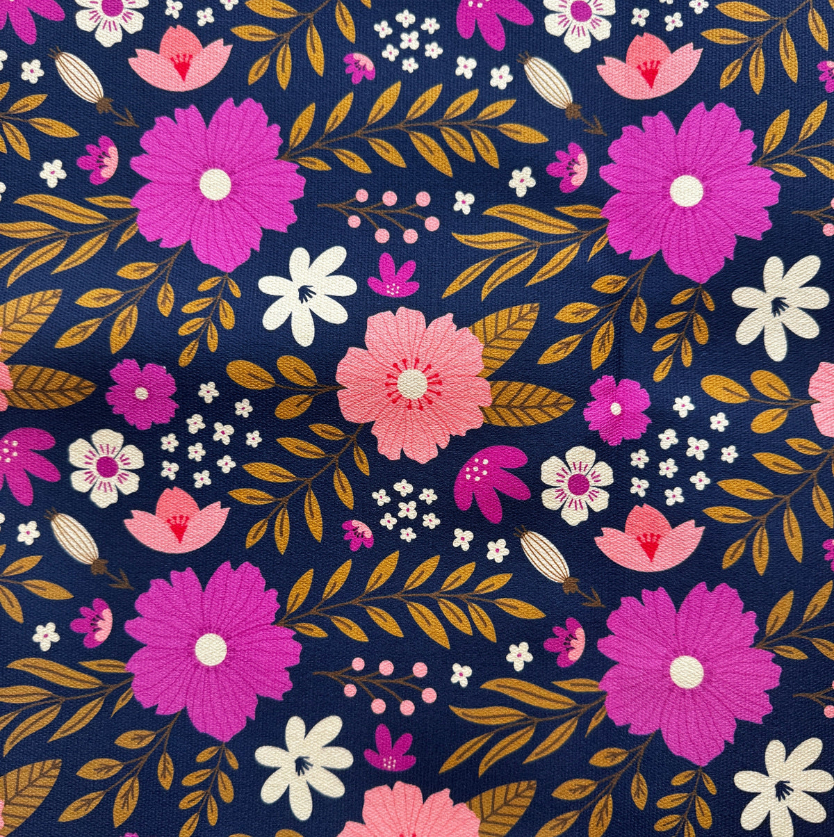 Close-up of Sew Hungry Hippie navy pink chamomile floral canvas fabric for bag making