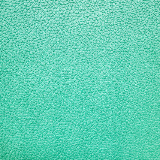 A close-up of a mint green pebbled leather texture filling the entire frame.